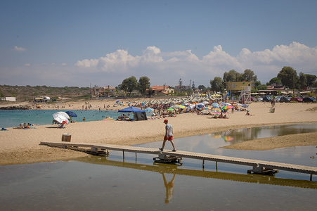 Tourists seen on a raised walkway at 
Stavros beach which is located on the northern side of Akrotiri in Crete Island.