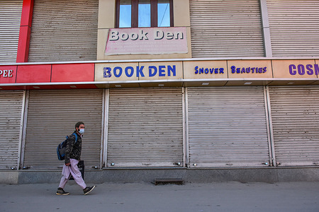 A commuter wears a protective face mask as he walks through a market partially closed following the second wave of Coronavirus in Srinagar.
India reported the world's highest daily tally of coronavirus infections for a second day on Friday, surpassing 330,000 new cases and 2256 deaths in the past 24 hours.