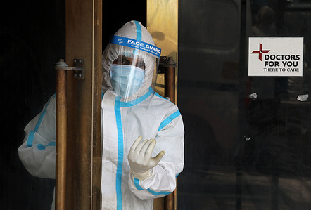 A healthcare worker in personal protective equipment (PPE) looks outside from the the door of isolation ward. A temporarily converted from banquet hall to Covid -19 ward for coronavirus patient. India the highest single-day spike in coronavirus infection. The report recorded 352,991 new Covid-19 cases and 2,812 people died from the virus in the last 24 hours amid an oxygen crisis.A banquet hall temporarily converted to a Covid19 ward for coronavirus patients. India has recorded the highest single-day spike in coronavirus infection. The report recorded 352,991 new Covid-19 cases and 2,812 people deaths in the last 24 hours amid an oxygen crisis.
