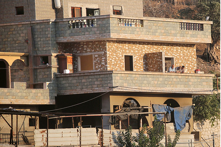 Relatives of Palestinian prisoner Dawas Hassoun in the village of Beit Amrin, northwest of Nablus in the West Bank, stand on the balcony of their home. Israeli authorities accused Hassoun of being responsible for the killing of Israeli settler Yehuda Sherman. Hassoun's family reported that Israeli forces informed them they must evacuate the house within 72 hours before its planned demolition with explosives.