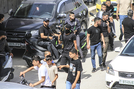 Gunmen march as mourners carry the bodies of Palestinians, some draped in the Islamic Jihad militant group flags during their funeral in the West Bank city of Jenin. The Israeli military said it has completed a two-day operation in the occupied West Bank that killed and wounded multiple Palestinians, according to the Palestinian Health Ministry. The Palestinian Islamic Jihad militant group said its fighters battled the Israeli forces.