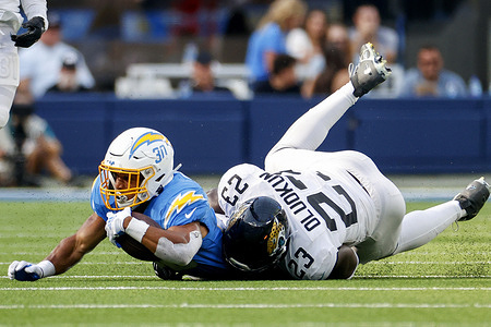 Los Angeles Chargers running back Austin Ekeler (No.30) and Jacksonville Jaguars outside linebackers Foye Oluokun (No.23) in action during the NFL football game between Los Angeles Chargers and Jacksonville Jaguars at SoFi Stadium. Final score; Chargers 10:38 Jaguars.