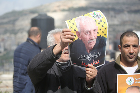 A Palestinian man seen holding up a picture of one of the Palestinian prisoners during the solidarity vigil in front of the International Committee of the Red Cross in Nablus, West Bank. The vigil also served as a protest against the death penalty law approved by the Israeli cabinet.
