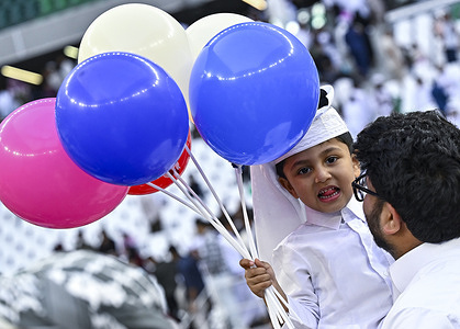 A boy celebrates with balloons after performing the Eid al-Adha morning prayers at the Education City Stadium. Muslims around the world are celebrating Eid al-Adha (the feast of sacrifice), the second of two Islamic holidays celebrated worldwide marking the end of the annual pilgrimage or Hajj to the Saudi holy city of Mecca.
