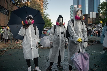 A group of protesters wearing raincoats hold umbrellas while waiting for police water cannon during the clashes.
Hong Kong police surround Polytechnic University during the fierce clashes. Clashes between protesters and riot police continued to erupt around Polytechnic University throughout the day. Police used the water cannon, fired teargas and rubber bullets while protesters responded with petrol bombs and bricks. Most of the fighting concentrated at the intersection in front of the school’s main entrance.