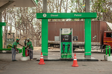 Fuel station employees are seen cordoning off a fuel machine. As the US/Israel-Iran conflict threatens the Strait of Hormuz, India’s 85% dependency on imported crude has reached a critical bottleneck. The surge in Brent benchmarks has collided with rigid domestic price caps, triggering widespread supply rationing. As New Delhi balances U.S. sanctions against surging internal demand, these disruptions signal the most severe stress test for the nation’s energy security.