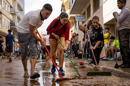 Volunteers are seen manually cleaning the streets in the town center during the cleaning operations in the aftermath of the storm Alice, which hit parts of the Catalonia and Valencia regions in Spain. Volunteers manually clean the streets in the town center after Storm Alice hit parts of Catalonia and Valencia, Spain. The storm brought record-breaking rainfall, the heaviest ever recorded for a Dana - a Spanish meteorological term meaning Depresión Aislada en Niveles Altos ("Isolated Depression in High Levels"), but fortunately, no injuries were reported.