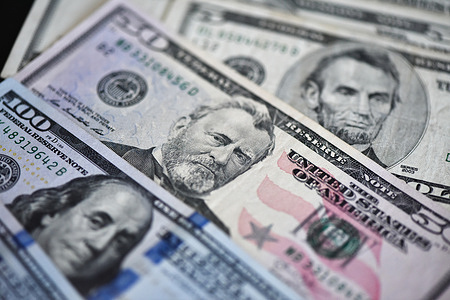 In this photo illustration, various US banknotes are layered and spread out.