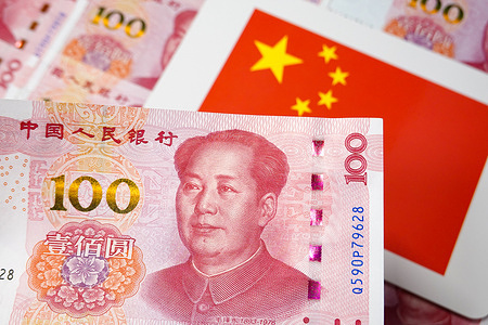 In this photo illustration, there is a 100-yuan RMB banknote with the Chinese national flag in the background.