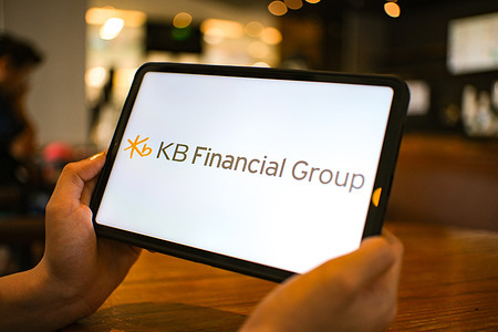 In this photo illustration, the KB Financial Group logo is seen displayed on a tablet screen.