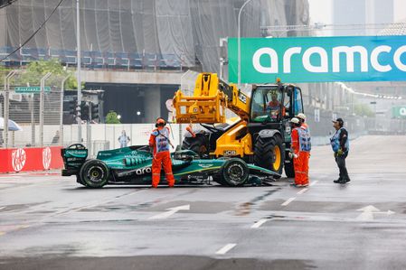 Track Marshals recover the car of Lance Stroll of Canada and the Aston Martin Aramco Formula One Team during the sprint race ahead of the F1 Grand Prix of Singapore at the Marina Bay Street Circuit.