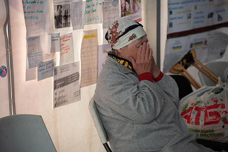 An elderly woman seen crying at a refugee center in Zaporizhzhia after arrival from the Russian-occupied territory. Sheets of paper are glued to the tent with messages that people write looking for their relatives who disappeared in Mariupol and other cities occupied by Russia. Zaporizhzhia remains a main border crossing point for refugees, with thousands of Ukrainians fleeing Russian-occupied territories fleeing the violence.