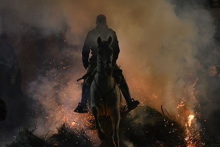 A man rides a horse through a bonfire as part of a ritual in honor of Saint Anthony the Abbot, the patron saint of domestic animals, in San Bartolome de Pinares, Spain.