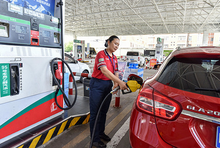 A female worker at a gas station pumps gas for a car in Fuyang. Starting August 10, domestic gasoline and diesel prices will increase, according to China's National Development and Reform Commission (NDRC). Domestic gasoline prices will increase by 240 yuan per ton, while diesel will increase by 230 yuan per ton. With this announcement, car owners went to gasoline stations to buy gasoline and diesel before the prices spike.