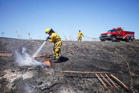 A firefighter is seen extinguishing the brush fire in Richmond. Firefighters responded to a brush fire in Richmond. The brush fire started around 1:22 p.m. and was contained by 2 p.m.The cause of the fire is the open burning of waste in the area.