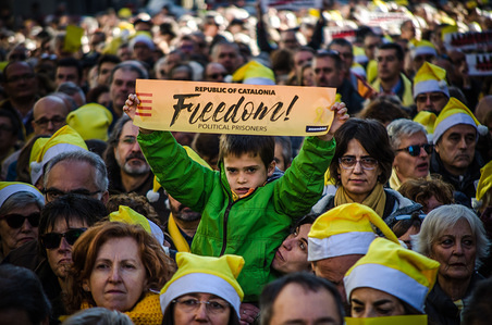 A child among the crowd seen showing a poster with the text "Free Catalan prisoners". The catalan sovereigntists organizations, Omnium Cultural and ANC, have called a Christmas song for freedom in front of the Barcelona's Modelo prison. Several hundred people have sung traditional Christmas songs as well as hymns in memory of the members of the catalan Government suspended still in prison.