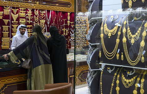 Women examine decorative gold jewelry on display at a shop in the Gold Center in Doha as demand for precious metals continues amid fluctuating global prices and the approach of the festive season.