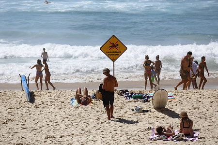 People cool off during hot weather at Bondi Beach. People gather at Bondi Beach, one of Australia’s most famous beaches, as Sydney records temperatures of around 33 °C. The beach, which attracts over 2 million visitors annually, sees crowds seeking relief from the heat. A month after a terrorist attack on Bondi, security remains tight and visitors stay alert.