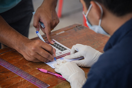 A man signs his name for provincial elections at a polling site in Nonthaburi.
 76 cities around Thailand set up provincial elections. This is the first provincial elections since 2014 after a coup led by the current prime minister Prayut Chan-o-cha.