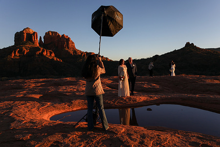 A wedding photoshoot capturing Cathedral Rock in the background takes place in secret Slickrock, Red Rock state park, Sedona.