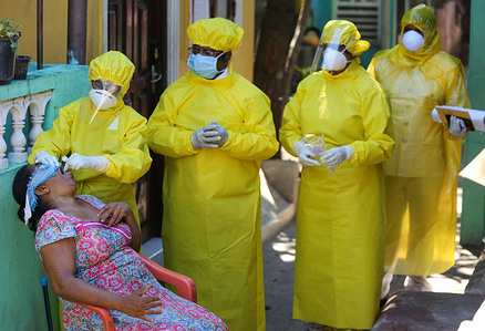 A health worker takes a swab test sample from a suspected woman, during the coronavirus pandemic.
Sri Lankan authorities claim they have largely managed to prevent community spreading through proper identification and isolation of people who came into contact with COVID-19 patients.