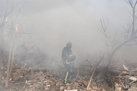 Ukrainian firefighters extinguish a fire in a residential building after a Russian bombing raid.