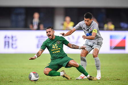 Leonardo (L) of Zhejiang FC and Tanaboon Kesarat of Port FC seen in action during the AFC Champion League Qualify Play off match between Zhejiang FC and Port FC at Huzhou Olympic Sports Center. (Final score; Zhejiang FC 1:0 Port FC )