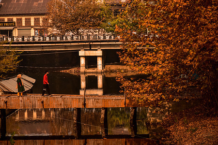 Residents walk through a wooden foot-bridge during an autumn day. Autumn, locally known as Harud is a season of harvesting with trees changing their colours while the day light hours become shorter as winter approaches.