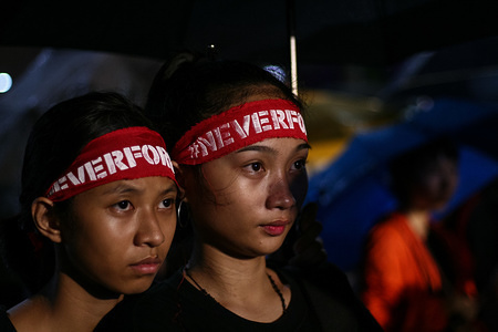 Student activists wearing Never Forget headbands look on during the evening program in Luneta Park. Students and activists lead a march to Luneta Park in Manila as they commemorate the 46th year anniversary of the Martial Law that Ferdinand Marcos imposed during his term.