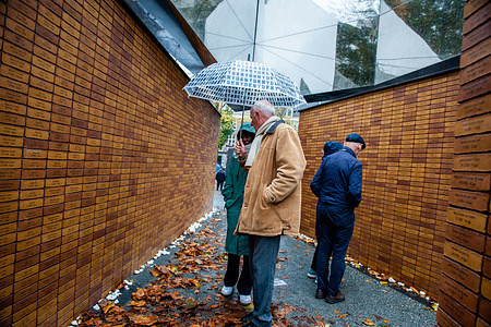 Local people visiting the memorial.
Seventy years after the Second World War, more than 102,000 victims of the Holocaust finally have their own memorial. This national memorial is located in the heart of the Jewish Quarter of Amsterdam. The memorial consists of a labyrinth of passageways flanked by two-metre-tall brick walls that convey the message ‘In memory of’. Inscribed on each of the bricks is the name of each victim of the Holocaust. Most of the people visiting the memorial, are holding papers with the names of their loved ones that they lost during WWII, in order to find the bricks with their names at the memorial to pay tribute to them.
