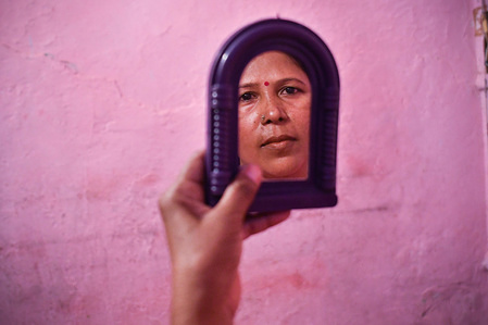 Liberated manual scavenger, Usha Chaumar, 40, looks on a mirror as she gets ready to go out in her house.
According to United Nation Manual scavenging refers to "the practice of manually cleaning, carrying, disposing or handling in any manner, human excreta from dry latrines and sewers. It often involves using the most basic of tools such as buckets, brooms and baskets. The practice of manual scavenging is linked to India’s caste system where so-called lower castes were expected to perform this job. Manual scavengers are amongst the poorest and most disadvantaged communities in India."

"In 1993, India banned the employment of people as manual scavengers. In 2013, landmark new legislation in the form of the Manual Scavengers Act was passed which seeks to reinforce this ban by prohibiting manual scavenging in all forms and ensures the rehabilitation of manual scavengers to be identified through a mandatory survey."
Nai Disha is one of the camps run by NGO aiming to help those been working in such poor condition in the past and help them to gain new skill to enable them to seek works with better condition.