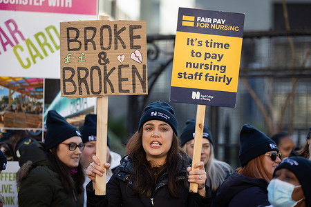 Nurses hold up placards expressing their opinion during the demonstration outside St Thomas' Hospital. The Royal College of Nursing has organized two days of strike action over their pay and working conditions. They also signaled a willingness to negotiate their original demand of a 19% pay rise.