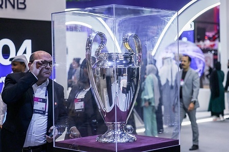 A visitor looks at the UEFA Champions League trophy won by Paris Saint-Germain during the Web Summit Qatar 2026 at the Doha Exhibition and Convention Centre (DECC) in Doha.