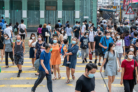 Pedestrians wearing face masks are seen crossing the road at a zebra crossing in Hong Kong.