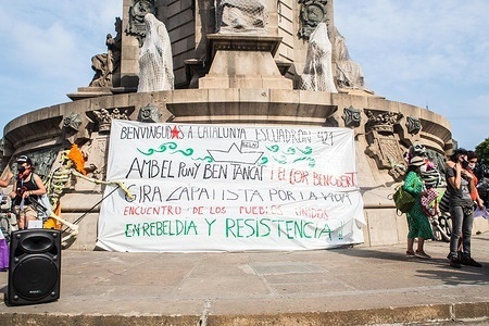 A banner at the Columbus Monument that says, Welcome to Catalonia, squad 421 with closed fists and open hearts, Zapatista tour for life, meeting of peoples united in rebellion and resistance, during the event.
Barcelona welcomes the 421 Squadron of the Zapatista Army of National Liberation (EZLN), a libertarian socialist political and militant group of Mexico, on their way through Europe. Composed of different members. The 421 Squad has been received at the Columbus Monument by local collectives and social organizations.