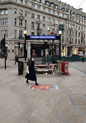 A woman wearing a face mask walks past an NHS sign outside the Oxford Circus Underground Station.
Most places have closed as the second month-long national lockdown takes hold in England.