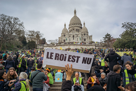 Protestor holding a sign saying : "the king is naked" at the footsteps of Basilica Sacre Coeur. During the XIX act of the French Yellow Vest movement, protesters gather at the footsteps of Basilic Sacre Coeur, north of Paris.