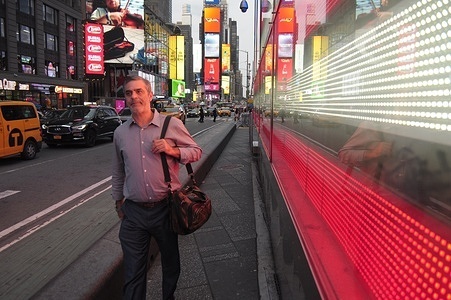 A person walks past a lighting installation of the American flag in Times Square, Manhattan, New York City.