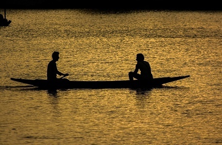 People seen using a boat at sunset.
Daily life at Dal Lake in Srinagar, Indian administered Kashmir.