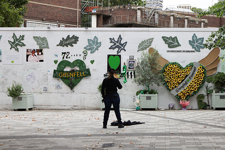 A woman looks at the Grenfell Tower Memorial Wall in west London.