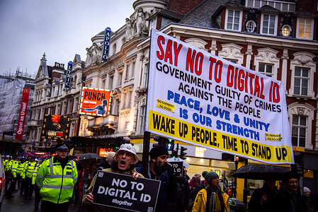 Protestors march with a large banner and placards during the Unite Against Digital ID Protest. Protestors were protesting against the introduction of digital ID in the UK, claiming that it would increase the government's surveillance powers while threatening individual privacy and freedom.