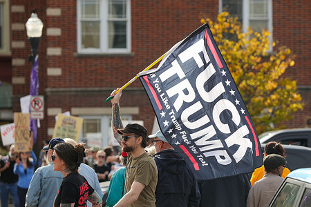 (EDITORS NOTE: Image contains profanity) A man holds an anti-Trump flag during a "No Kings" protest. More than 2,500 No Kings protests against the Trump administration were scheduled across the United States.