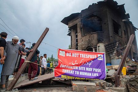 Kashmiri residents inspect the gun battle site after operation ended at Nihama area of Pulwama district, south of Srinagar. Top Lashkar-i-Toiba commander and eight-year longest surviving militant Riyaz Ahmad Dar and his associate were killed in an encounter a day before counting votes for the Lok Sabha, or lower house, of Indian parliamentary elections in the Himalayan disputed region.