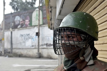 An Indian paramilitary trooper stands alert during restrictions in Srinagar, Indian administered Kashmir. Authorities imposed restrictions in parts of Srinagar as separatists called for a shutdown against “brutal killing” of Hurriyat leader Muhammad Yousuf Nadeem, shifting political inmates and lifers from Srinagar central jail and staying of FIR against Army Major in Shopian killings by Supreme Court.