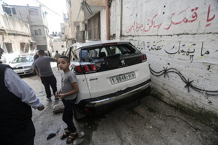 Palestinians stand near a destroyed car after Israeli forces raided the Balata refugee camp east of the West Bank city of Nablus. Israeli forces launched a military raid on the Balata refugee camp east of the West Bank city of Nablus, killing a Palestinian.