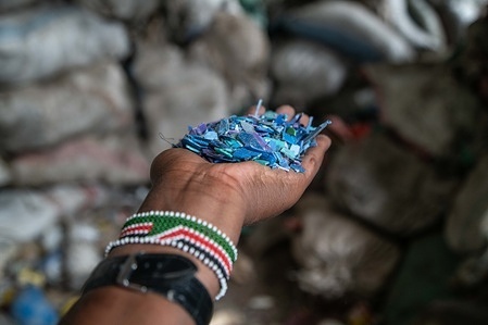 A detail of a man's hands holding shredded plastic at a recycling plant near Nakuru Town. The Intergovernmental Negotiating Committee (INC2) is convening in Paris, France, to develop details for a legally binding plastics treaty aimed at eradicating plastic pollution worldwide.