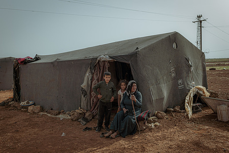 Mariam Hallil from the Al-Hasakah area with her children in an improvised refugee camp near Da'el. Devastating convergence of climate crisis and war's aftermath in Daraa province. Once known as southern Syria's breadbasket with fertile lands sustained by advanced irrigation systems, the region now faces its worst drought in over 25 years, with reservoir levels plummeting from 33 million to just 3 million cubic meters. The 13-year civil war destroyed crucial water infrastructure and turned water access into a weapon of warfare, while desperate farmers drilled tens of thousands of random wells that accelerated groundwater depletion. Israel's December 2024 occupation of the strategic Al-Mantara Dam following Assad's fall has further complicated the crisis, threatening the region's remaining water security. With the Yarmouk River completely dried, crops withering, livestock dying, and no prospects for improvement, Daraa's farmers who fought for over a decade for their land increasingly see emigration as their only future.