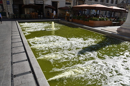 People sit on the terrace of a restaurant near the basin at the "Cours d'Estienne d'Orves" in Marseille.