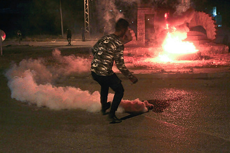 A Palestinian burns tires as they block roads leading to Joseph's tomb in front of the Jewish settlers during a protest against their visit to the tomb, in the city of Nablus in the occupied West Bank.