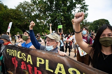 Protesters hold a banner while making gestures during the demonstration.
Hundreds of demonstrators gathered outside The White House to call on President Joe Biden to divest from fossil fuels and invest in a clean energy future. Over 60 protesters were arrested.